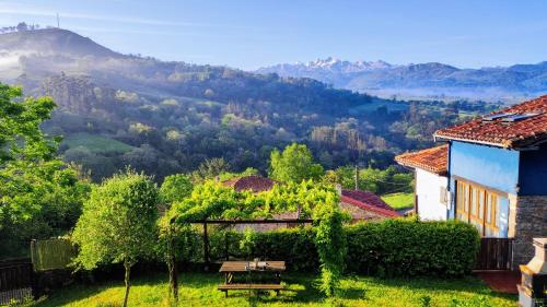 a house with a picnic table and a view of a mountain at La Casina de Labra in Cangas de Onís