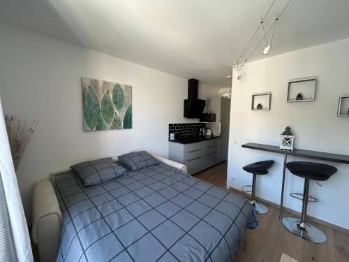 - une chambre avec un lit et deux tabourets dans l'établissement Les Embruns - studio cosy plage & centre - dog friendly, à Villers-sur-Mer