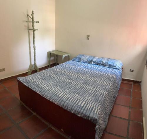 a bed in a room with a cross on the wall at Cobertura Aconchegante na Enseada 3 Quartos, Piscina e Conforto a Poucos Passos do Mar in Guarujá
