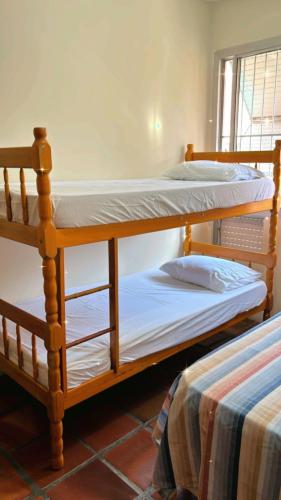two bunk beds sitting next to each other in a room at Cobertura Aconchegante na Enseada 3 Quartos, Piscina e Conforto a Poucos Passos do Mar in Guarujá