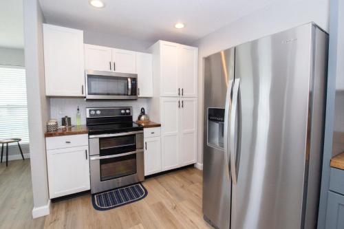 a kitchen with white cabinets and a stainless steel refrigerator at The Zen Den in Waynesville