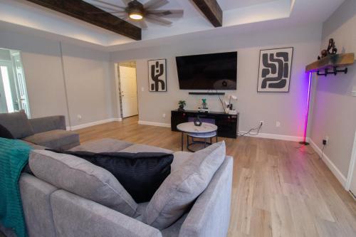 a living room with a couch and a tv at The Zen Den in Waynesville