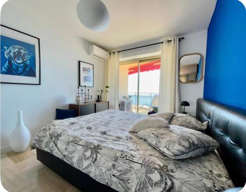 une chambre avec un grand lit avec un mur bleu dans l'établissement Magnifique appartement - Vue mer, à Nice