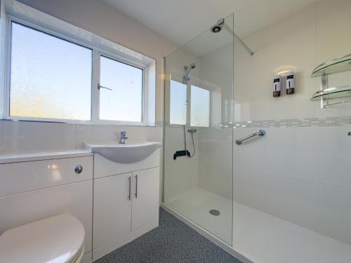 a white bathroom with a sink and a shower at Urban Ease Basildon in Basildon