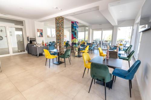 a dining room with tables and chairs and a cafeteria at Boutique Hotel IVY'Z in Novalja