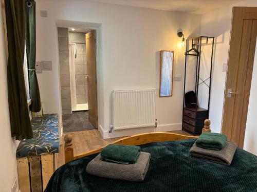 a bedroom with a bed with two green pillows on it at Ardenbeg in Grantown on Spey