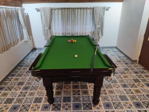 a green pool table with a ball on it at Maharanee Bungalow Darjeeling in Darjeeling
