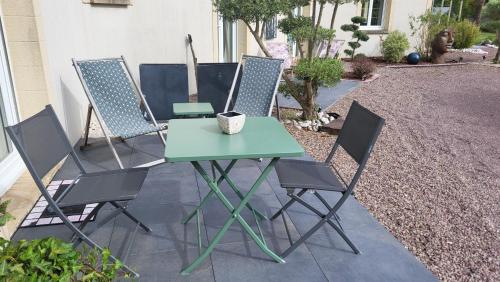 une table et quatre chaises sur la terrasse dans l'établissement Le coup de foudre, à Le Molay-Littry
