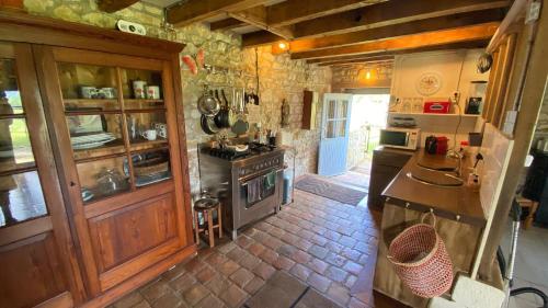 a kitchen with a stove and a sink in it at La Bergerie in Thollet