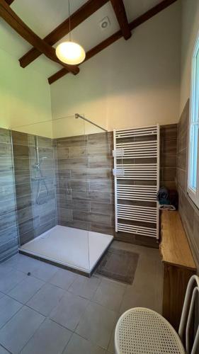 une salle de bain avec une douche avec une porte vitrée dans l'établissement gite a la campagne, à Noailhac