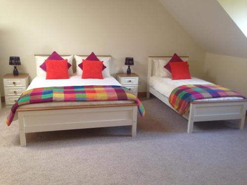 a bedroom with two beds with colorful pillows at Railway View - Connemara in Recess
