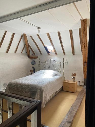 a bedroom with a bed in a room with beams at La Bergerie in Thollet