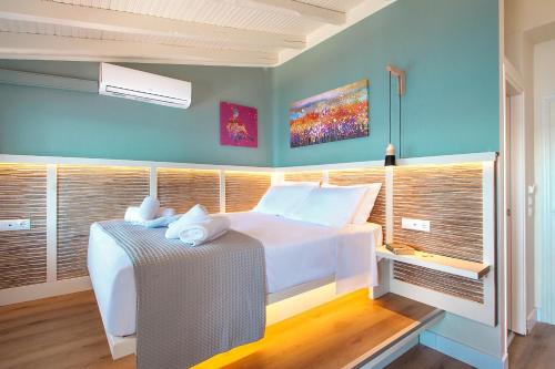 a bedroom with a large white bed and some windows at amfiliki in Skiathos Town