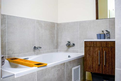 a bathroom with a tub and a sink at Royal Golfview Stay in Boksburg