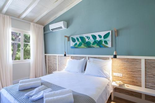 a blue bedroom with a bed with white sheets and pillows at amfiliki in Skiathos Town