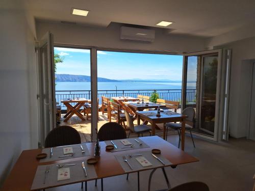 un ristorante con tavoli e sedie e vista sull'oceano di SUZANA Beautiful balcony sea view 1 a Senj