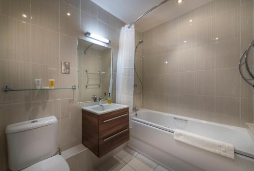 a bathroom with a tub and a sink and a toilet at The Three Swans Hotel, Market Harborough, Leicestershire in Market Harborough