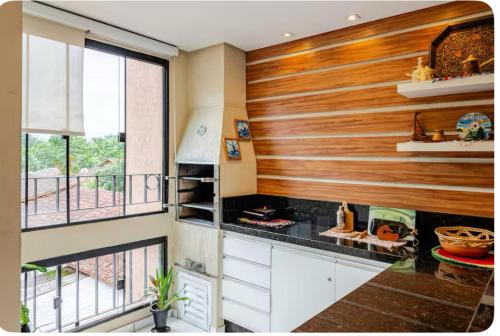 eine Küche mit einem Herd und einem Balkon in der Unterkunft Apto Ubatuba home - Centro c vista in Ubatuba