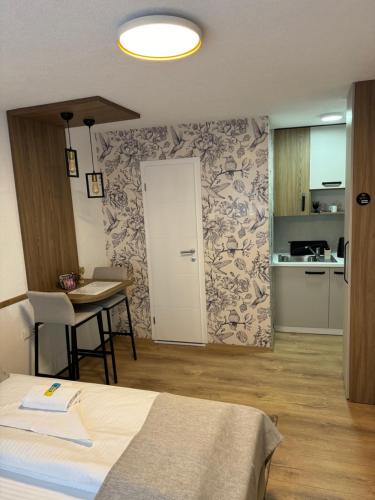 a room with a bed and a table and a door at Apartments HAN 2 Sarajevo in Sarajevo