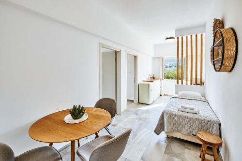 a bedroom with a bed and a table and chairs at Golden Beach Hotel in Chrissi Akti