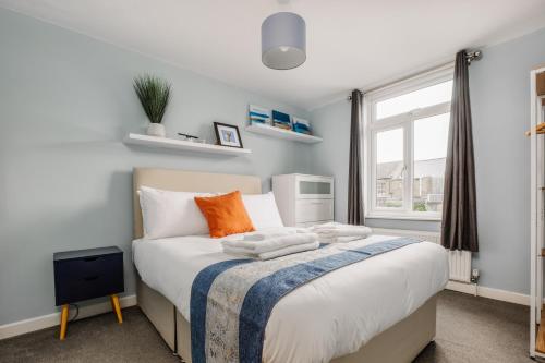 Un dormitorio con una cama y una ventana en Modern Hove Home close to Brighton Beach with FREE PARKING, en Brighton & Hove