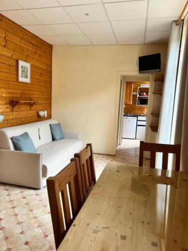 a living room with a white couch and a table at Résidence Les Dômes in Murol