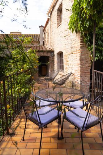 a patio with a table and chairs and a building at La Vieille Demeure in Torreilles