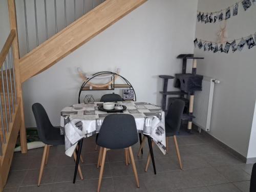 une salle à manger avec une table et des chaises dans l'établissement Maison 2 chambres proche circuit, à Changé