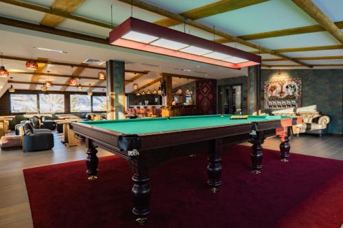 a pool table in a room with a bar at Lilat Hotel in Mestia