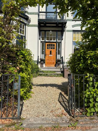 an entrance to a house with an orange door at B&B Villa Frisia in Steenwijk