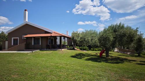 a house with a tree and a grass yard at Casa Dikella in Mesimvría