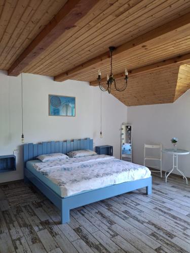 a bedroom with a blue bed and a wooden ceiling at Pensiunea HAPPY in Schitu-Topolniţei