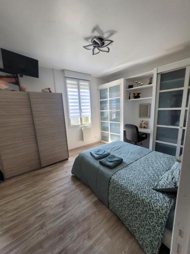 une chambre avec un lit et un ventilateur de plafond dans l'établissement Une petite campagne en ville, au Mans