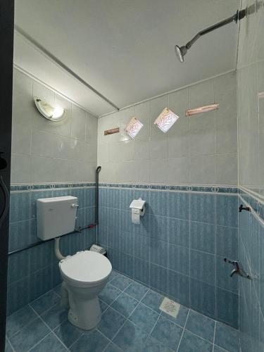 a bathroom with a toilet and blue tiles at Rumah Bonda in Gua Sai