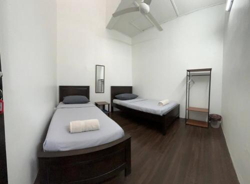 Una habitación con dos camas y un sofá. en Rumah Bonda, en Gua Sai