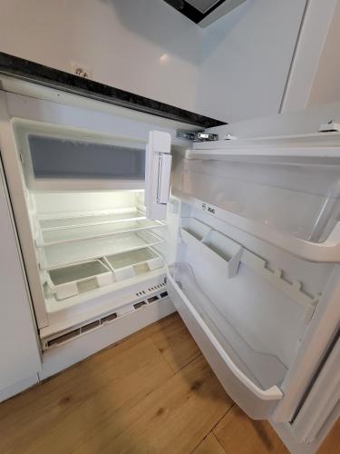 an empty refrigerator with its door open in a kitchen at City Center Zurich Downtown Apartments next to Zurich HB Main Train Station NEU - Self Checkin in Zürich