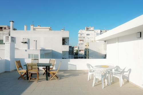 un patio con tavolo e sedie sul tetto di Dona Maria Guest House a Faro