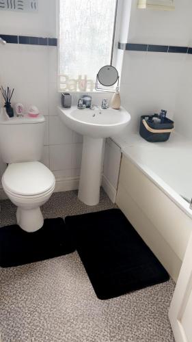 a bathroom with a white toilet and a sink at Gravesend Guest Retreat in Gravesend