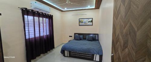 a bedroom with a bed with blue sheets and a window at NATURE GREEN faarm in Dahmi