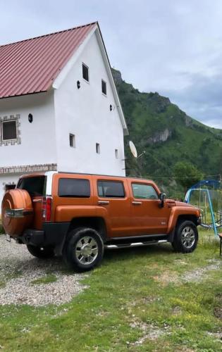 an orange truck parked in front of a house at Bujtina Mark Alia in Vrana