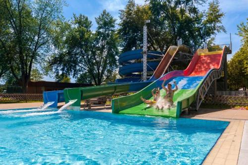a pool with a water slide in a park at Mobile House LaSiesta Thermal park Terme 3000 in Moravske Toplice