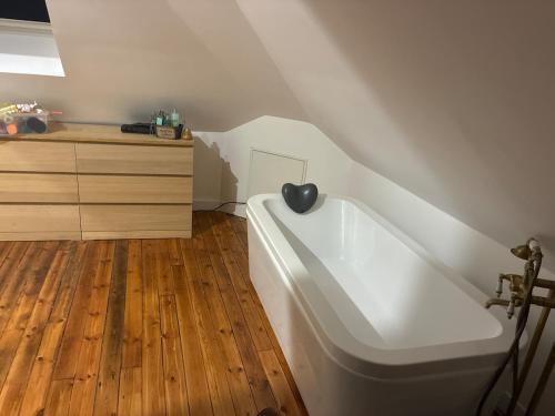 Cette chambre dispose de parquet et d'une baignoire blanche. dans l'établissement Le clos de Montherlant, à Saint-Crépin-Ibouvillers