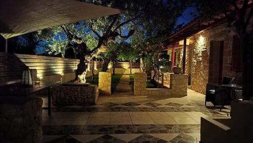 a building with a tree in a courtyard at night at George's Houses in Riglia