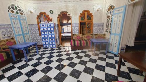 a doll house with two chairs and a checkerboard floor at Hostel ALINE in Chefchaouene