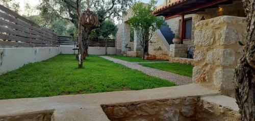 a building with a garden with a tree in the yard at George's Houses in Riglia