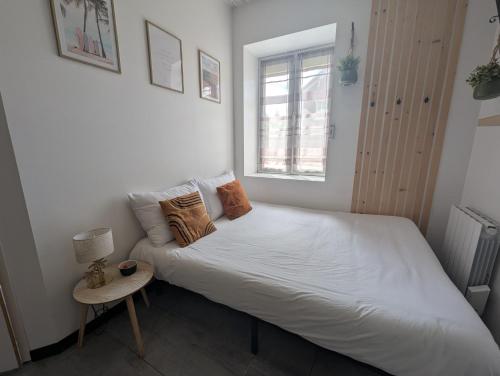 une chambre avec un lit blanc et une fenêtre dans l'établissement Studio cosy proche du centre-ville, à Paray-le-Monial