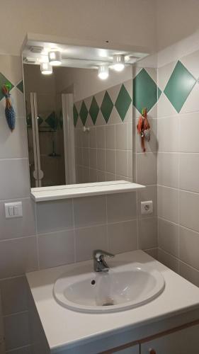 une salle de bain avec un lavabo et un miroir dans l'établissement La maison de Noelle, à Vaison-la-Romaine