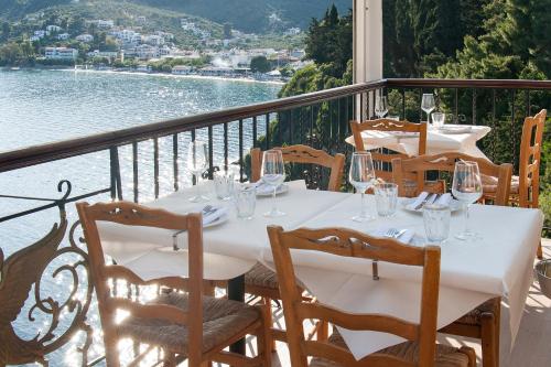 a white table with wine glasses on a balcony at amfiliki in Skiathos Town