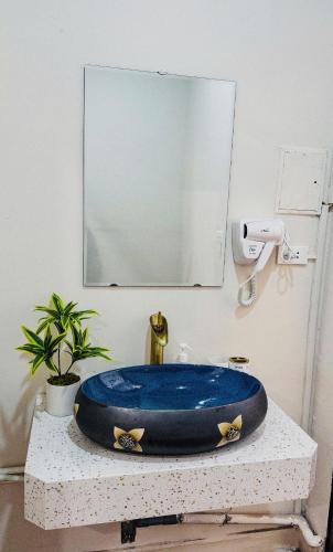 a blue sink in a bathroom with a mirror at SuGar Homestay in Hanoi