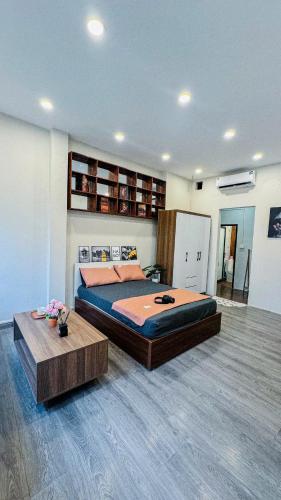 a bedroom with a large bed and a coffee table at SuGar Homestay in Hanoi